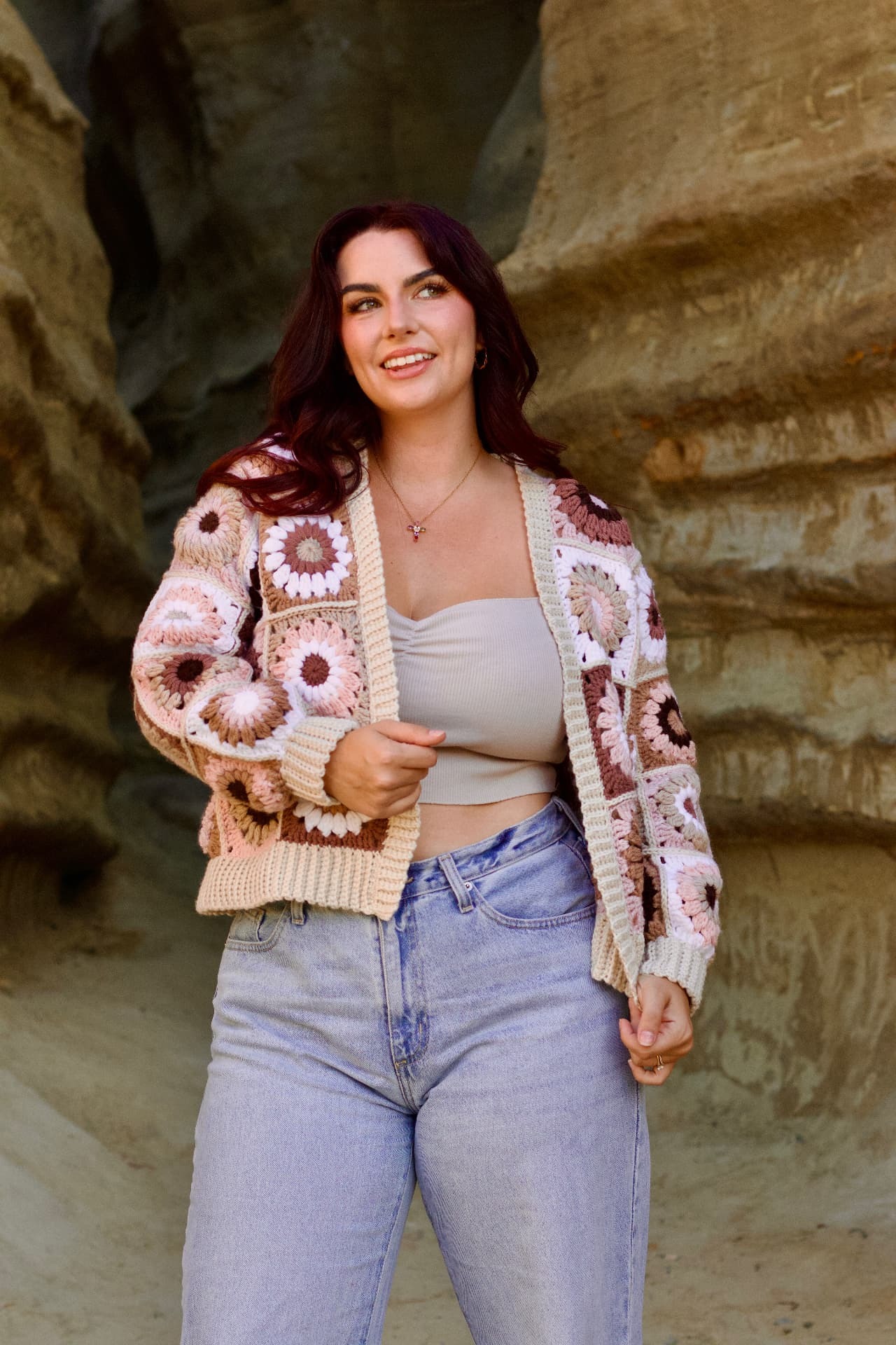 Client before the program, standing in a sandy canyon in a crochet cardigan