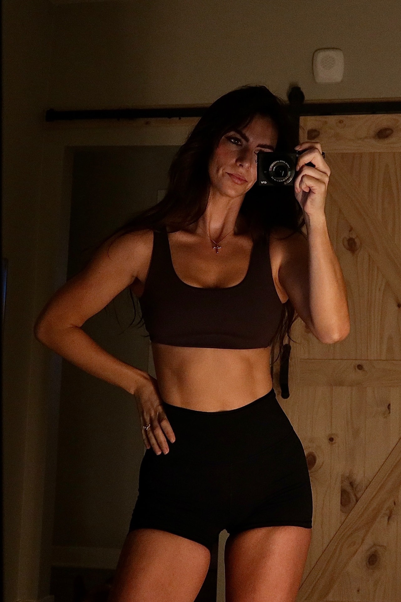 Client after the program, taking a mirror selfie in black training wear
